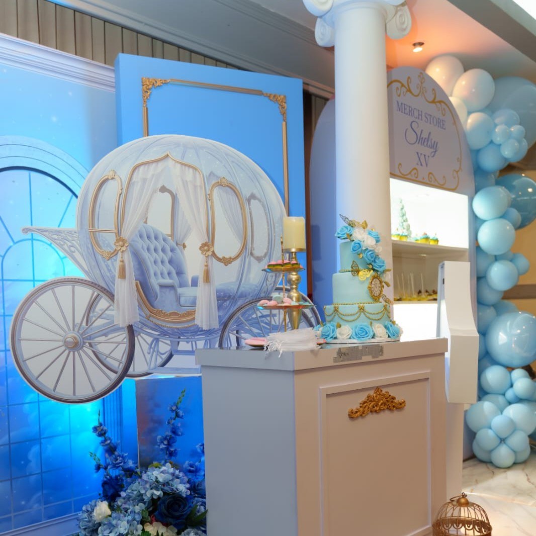 Vista amplia del carruaje de Cinderella junto al Merch Store y arco de globos para la Experiencia Creativa Medium