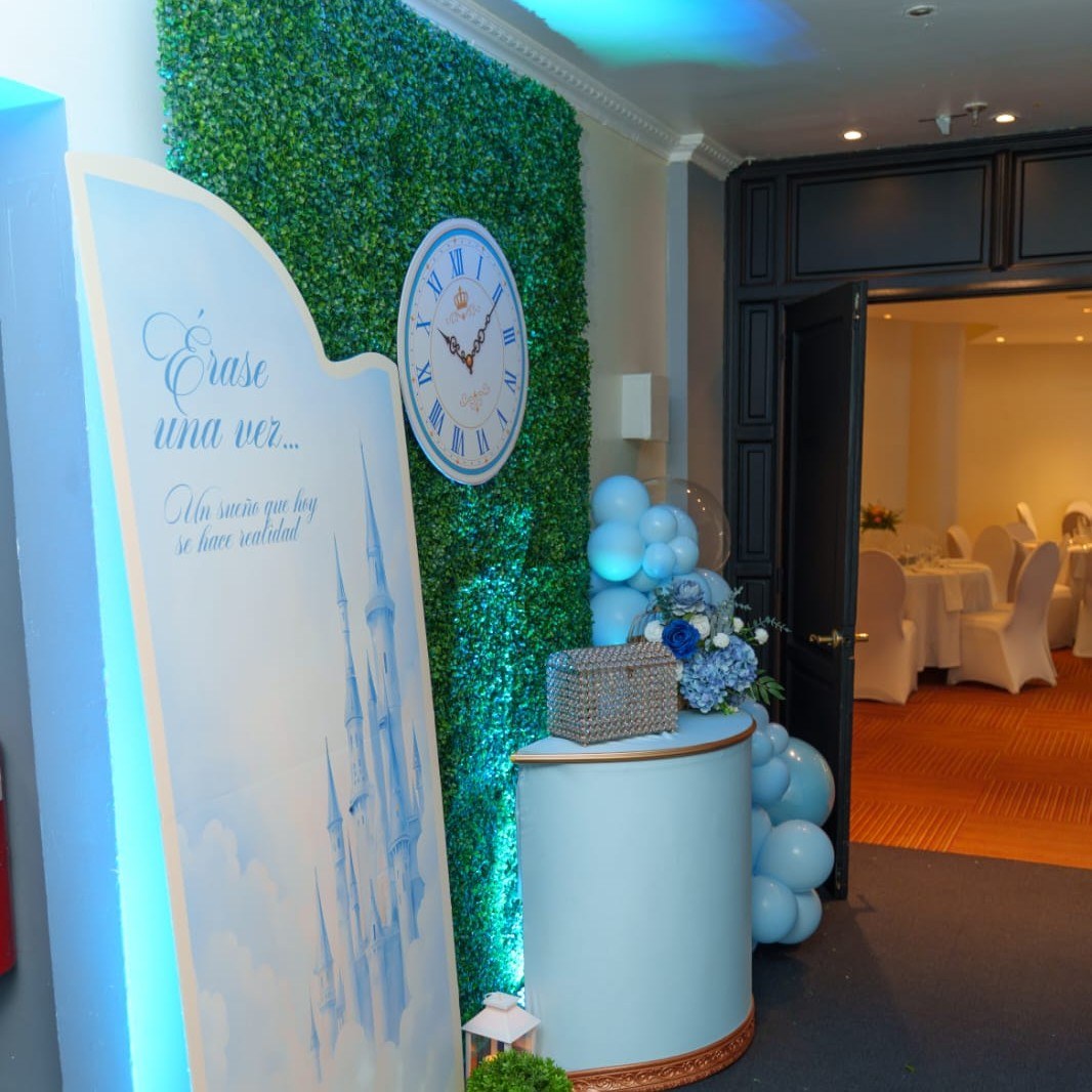 Ambientación de entrada "Érase una vez" con reloj, pared de jardín y cofre decorativo para la Experiencia Creativa Medium