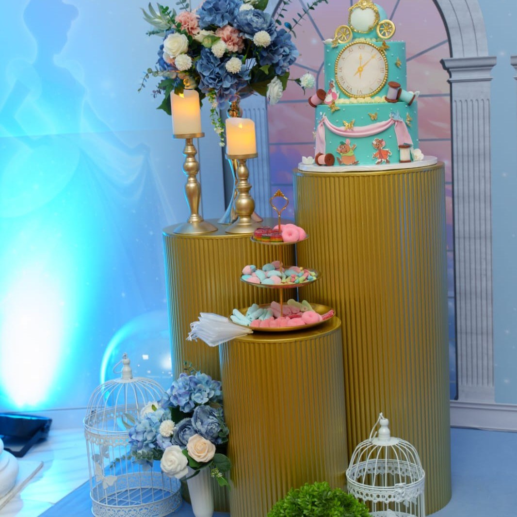 Pedestales dorados con pastel, dulces y jaulas decorativas blancas para la Experiencia Creativa Medium